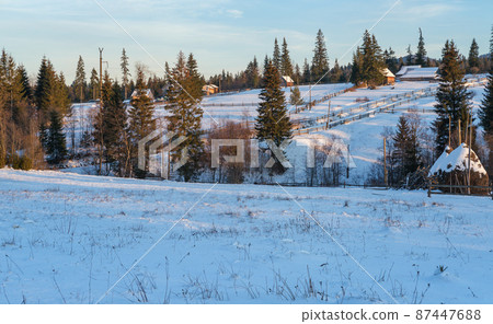 Winter remote alpine mountain village outskirts, countryside hills, groves and farmlands. Winter remote alpine mountain village outskirts, countryside hills, groves and farmlands. 87447688