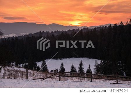 Small alpine village and winter snowy mountains in first sunrise sunlight around, Voronenko, Carpathian, Ukraine. Small alpine village and winter snowy mountains in first sunrise sunlight around, Voronenko, Carpathian, Ukraine. 87447694