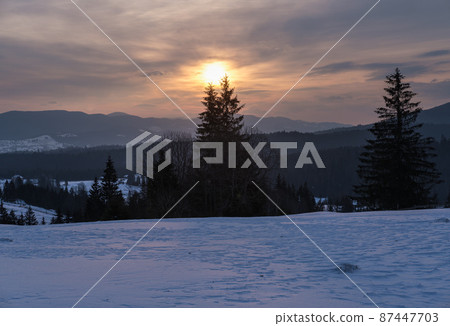 Small alpine village and winter snowy mountains in first sunrise sunlight around, Voronenko, Carpathian, Ukraine. Small alpine village and winter snowy mountains in first sunrise sunlight around, Voronenko, Carpathian, Ukraine. 87447703