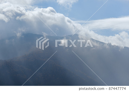 Morning foggy clouds in sunlight and autumn mountain countryside. Ukraine, Carpathian Mountains, Borzhava Range, Transcarpathia. Morning foggy clouds in sunlight and autumn mountain countryside. Ukraine, Carpathian Mountains, Borzhava Range, Transcarpathia. 87447774
