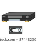 An analog VCR and videotape next to it. 87448230