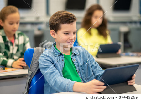 Boy looking at tablet at school lesson Boy looking at tablet at school lesson 87449269