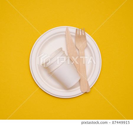 paper cups and plates on a yellow background. Recyclable garbage, rejection of plastic 87449915