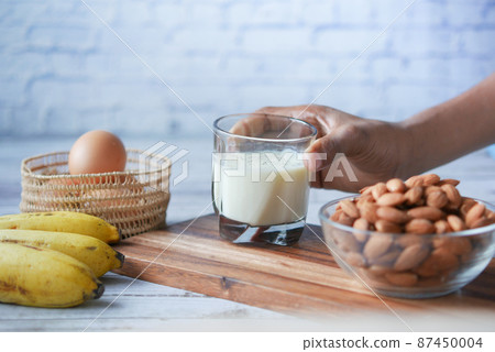 glass of milk, banana, almond nut on table glass of milk, banana, almond nut on table 87450004