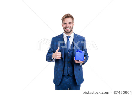 businessman in businesslike suit hold gift box as business reward showing thumb up, giftbox. 87450904