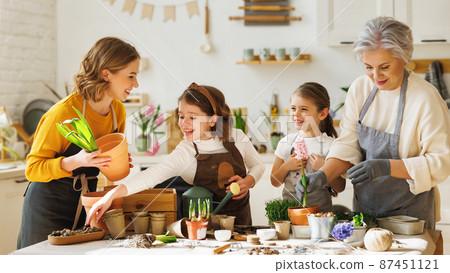 Happy family transplanting plants together at home 87451121