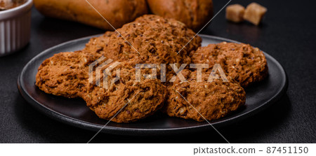 Tasty fresh oat cookies on a dark concrete background Tasty fresh oat cookies on a dark concrete background 87451150
