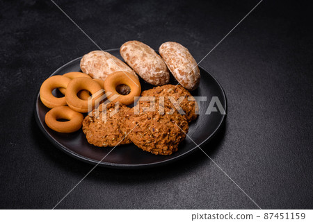 Tasty fresh oat cookies on a dark concrete background 87451159
