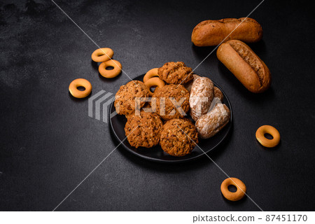 Tasty fresh oat cookies on a dark concrete background Tasty fresh oat cookies on a dark concrete background 87451170
