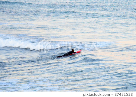 Surfer on board is surfing in sea 87451538