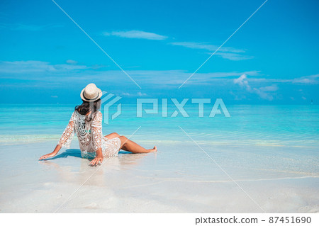 Woman laying on the beach enjoying summer holidays looking at the sea Woman laying on the beach enjoying summer holidays looking at the sea 87451690