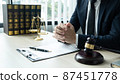 Counselor lawyer or notary working on a documents and report of the important case and wooden gavel, brass scale on table in courtroom 87451778
