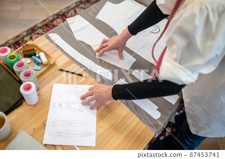 Top view of designers hands touching pattern and sketch 87453741