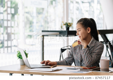 Happy asian woman hands holding credit card and using laptop computer. Online shopping concept. 87457117