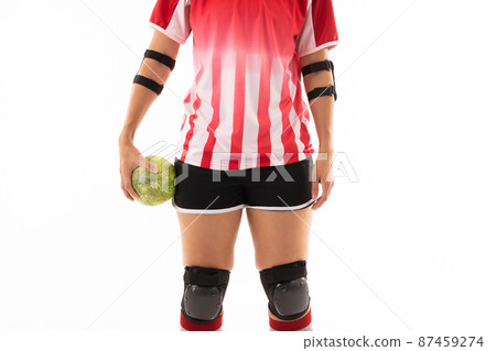 Midsection of biracial young female handball player with ball standing against white background 87459274