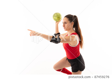 Caucasian young female player with arm outstretched and handball against white background 87459276
