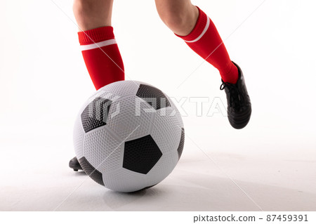 Low section of caucasian young female soccer player playing soccer against white background 87459391