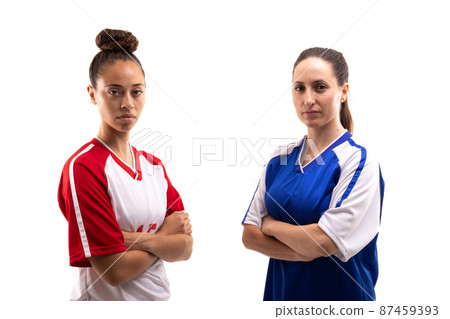 Portrait of biracial and caucasian young female soccer players standing with arms crossed Portrait of biracial and caucasian young female soccer players standing with arms crossed 87459393