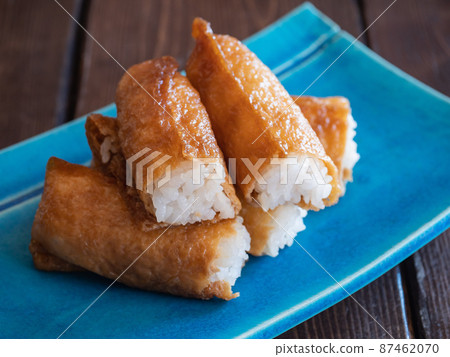 Inari sushi. Japanese cuisine made by simmering vinegared rice in sweet fried tofu. Inari sushi. Japanese cuisine made by simmering vinegared rice in sweet fried tofu. 87462070