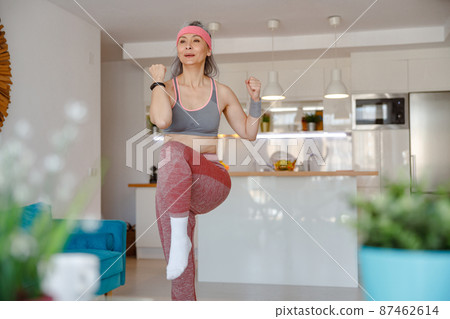 Woman in sportswear having workout in living room 87462614