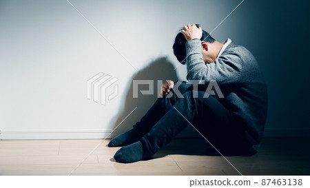 A man with a mental illness is holding his knee A man with a mental illness is holding his knee 87463138