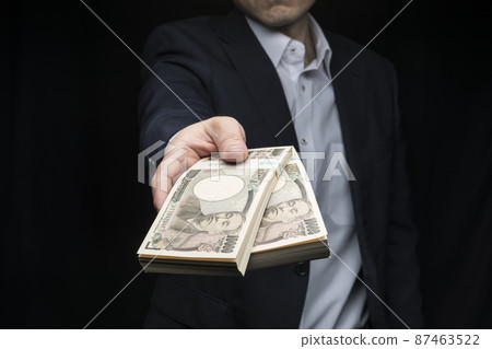 A man holding a wad of bills 87463522