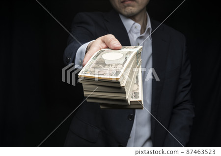 A man holding a wad of bills 87463523