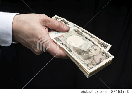 A man's hand holding a wad of bills 87463528