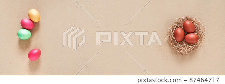 Banner with a nest and Easter eggs on a beige background. Minimal concept from two sides. Top view. With space to copy. High quality photo 87464717