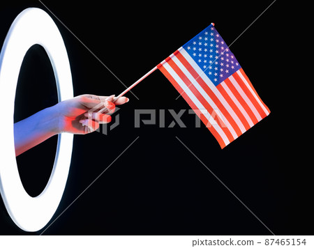 USA flag. Independence day. Patriotic pride. 4th July. Female hand holding American national symbol in glowing LED light ring isolated on black background. USA flag. Independence day. Patriotic pride. 4th July. Female hand holding American national symbol in glowing LED light ring isolated on black background. 87465154