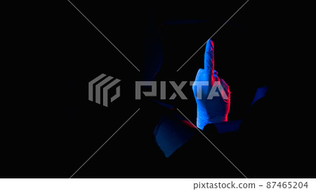 Fuck off. Obscene gesture. Red blue neon light rude doctor hand in glove showing middle finger inside breakthrough torn wall hole isolated on black night empty space banner. Fuck off. Obscene gesture. Red blue neon light rude doctor hand in glove showing middle finger inside breakthrough torn wall hole isolated on black night empty space banner. 87465204