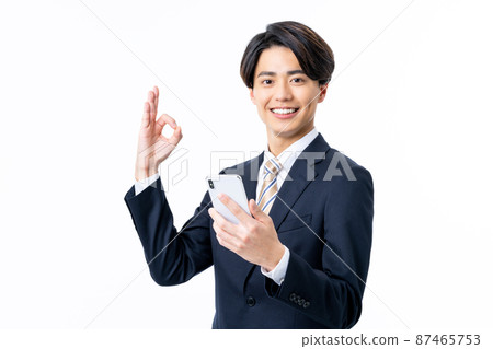 一個年輕的商人看著白色背景中的智能手機 87465753
