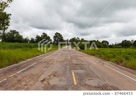 Damaged asphalt pavement road with potholes Damaged asphalt pavement road with potholes 87466453