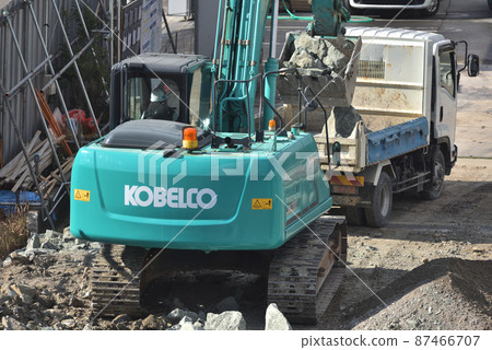 Construction site: Work scene of carrying out surplus soil with heavy machinery 87466707