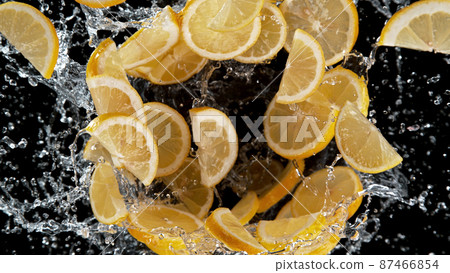 Freeze motion of sliced lemons in water splash. 87466854