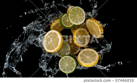 Freeze motion of sliced limes and lemons in water splash. 87466858