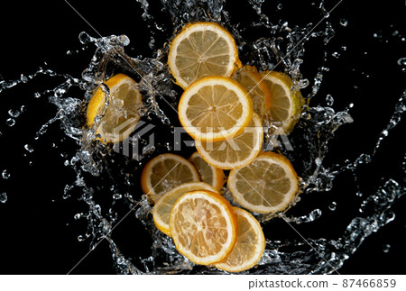 Freeze motion of sliced lemons in water splash. 87466859