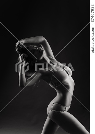Seductive woman in bikini having fun laughing with her long hair flying free Seductive woman in bikini having fun laughing with her long hair flying free 87467958