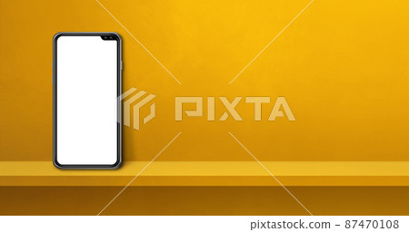 Mobile phone on yellow wall shelf. Background banner 87470108