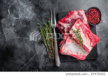 Veal beef Short Ribs, raw sparerib on marble board. Black background. Top view. Copy space 87470562