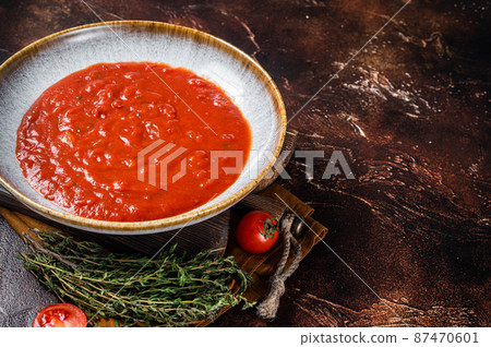 Homemade tomato Passata in rustic plate with herbs. Dark background. Top view. Copy space Homemade tomato Passata in rustic plate with herbs. Dark background. Top view. Copy space 87470601