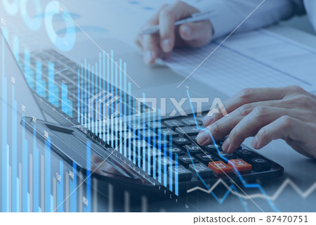 Image of analyzing financial data. A man who calculates with a calculator. Numerous graphs and charts. Laptop and notebook on the desk 87470751