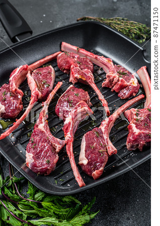 Ready for cooking Raw lamb, mutton chops steaks in a pan with herbs. Black background. Top view Ready for cooking Raw lamb, mutton chops steaks in a pan with herbs. Black background. Top view 87471150