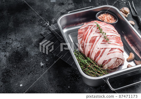 Cooking raw meatloaf with ground beef meat and bacon in steel tray, fresh meat loaf. Black background. Top view. Copy space Cooking raw meatloaf with ground beef meat and bacon in steel tray, fresh meat loaf. Black background. Top view. Copy space 87471173