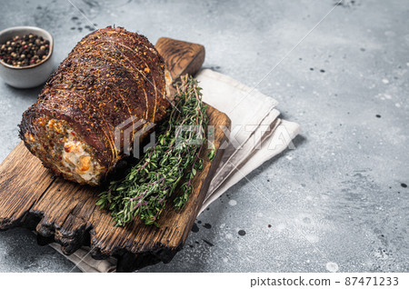Roast pork roulade Porchetta, pork meat meal on a wooden board. Gray background. Top view. Copy space Roast pork roulade Porchetta, pork meat meal on a wooden board. Gray background. Top view. Copy space 87471233