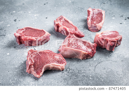 Raw fresh lamb loin chops cutlets. Gray background. Top view 87471405
