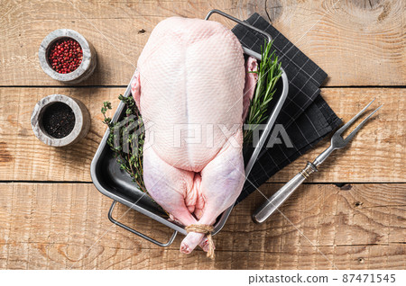 Cooking Christmas Raw whole duck with herbs and spices. Wooden background. Top view Cooking Christmas Raw whole duck with herbs and spices. Wooden background. Top view 87471545
