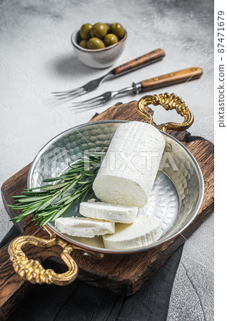 Goat soft cheese chevre in a skillet. White background. Top view 87471679