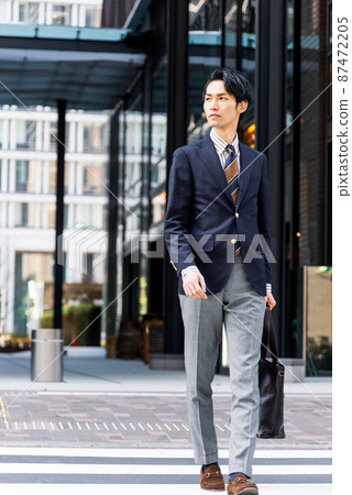 Businessman walking in the office town Businessman walking in the office town 87472205