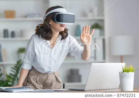 Woman with VR virtual reality goggles 87472231
